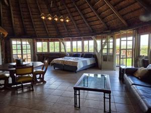 a living room with a bed and a table at Vaalkrans Game Lodge in Heilbron +36 photos