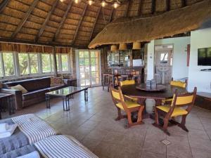 a large living room with a table and a couch at Vaalkrans Game Lodge in Heilbron