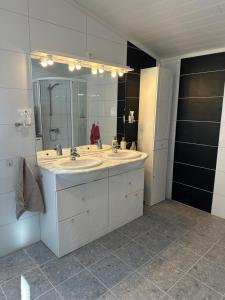 a bathroom with two sinks and a large mirror at Familievennlig fritidsbolig i hjertet av Flå, perfekt for besøk i Bjørneparken in Flå