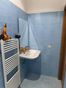 a blue tiled bathroom with a sink and a mirror at B&B Sorgenti del Gari in Cassino