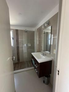 a bathroom with a sink and a shower with a mirror at Arenas Garzón in José Ignacio