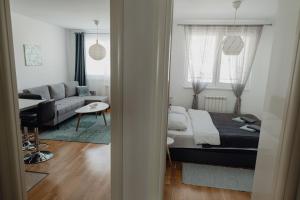 a bedroom with a bed and a living room at SK Blue apartment in Lukavica