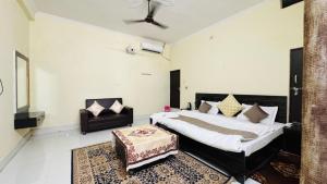 a bedroom with a king sized bed and a couch at Hotel Orchha Inn in Orchha