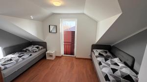 a attic bedroom with two beds and a window at Domki Premium Nad Bałtykiem in Wodnica