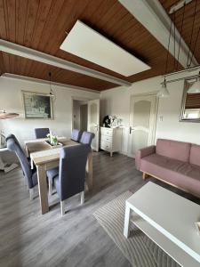 a living room with a dining table and a couch at Deichbrise in Aventoft