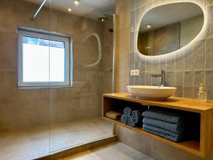 a bathroom with a sink and a mirror at Berghaus Wanderlust in Mallnitz +99 photos