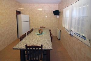 a dining room with a table and chairs and a refrigerator at Vivenda Principe in Geres