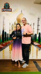 a man and a woman standing in front of a mosque at Zipcode Stay in Agra