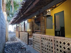 a yellow building with a fence next to a street at Sunset View Guest House in Camiguin