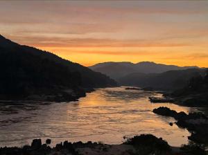 a view of a river at sunset at Pakbeng Backpackers in Pakbeng
