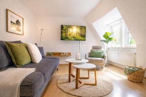 a living room with a couch and a table at ErzGlück Modernes Dachgeschoss-Apartment I nahe Altstadt I Stellplatz & Waschmaschine in Neuwelt