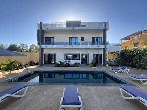 a villa with a swimming pool and a house at Chez Elisa in Mbour