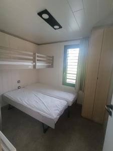 a small bedroom with a bed and a window at Cottage haut de gamme, tout confort in Agde