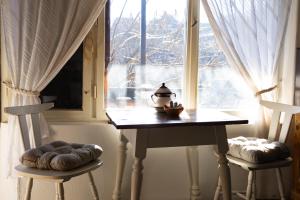 a table and two chairs in front of a window at Menyecske Guesthouse in Keszü