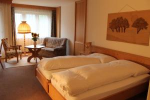 a bedroom with two beds and a chair and a table at Gemeinschaftshaus im Oberdorf in Lützelflüh