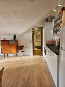 a kitchen with white walls and a wooden floor at Mariustova close to the airport in Ryggur