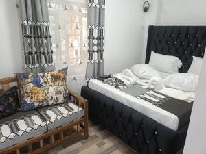 a bedroom with a bed with a black head board at Escape Retreats in Diani Beach +21 photos