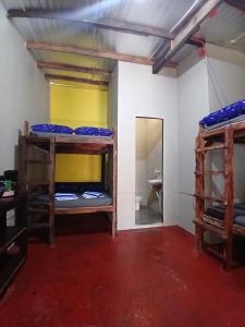 a room with three bunk beds and a mirror at Sunset View Guest House in Camiguin