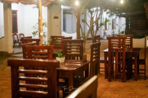 a row of wooden tables and chairs in a restaurant at The Dream Bay in Arugam Bay