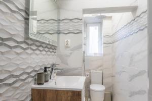 a white bathroom with a sink and a toilet at NDK - UrbanLux Medius 2BDR FREE Parking in Sofia +53 photos