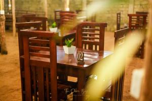 a wooden table with chairs and a table with a plant on it at The Dream Bay in Arugam Bay +56 photos