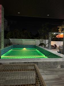 a swimming pool with green lights in a backyard at Tam Coc Natura Hotel in Văn Lâm