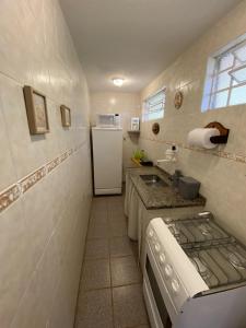 a small kitchen with a sink and a refrigerator at Campos do Jordão à moda antiga in Campos do Jordão