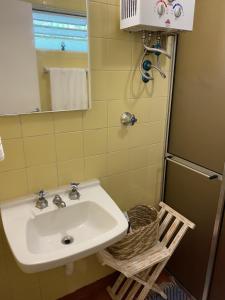 a bathroom with a sink and a mirror and a basket at Campos do Jordão à moda antiga in Campos do Jordão +19 photos