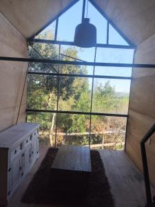 a large window in a room with a bench and a table at Cabañita para 2 in Villa Serrana
