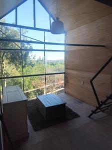 a room with a bench and a large window at Cabañita para 2 in Villa Serrana