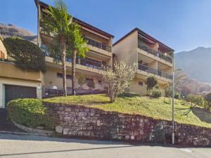 a large building with palm trees in front of it at La fornace lago in Melano
