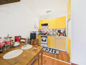 a kitchen with yellow cabinets and a wooden table at La fornace lago in Melano