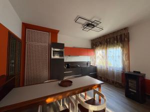 a kitchen with red cabinets and a table with chairs at L'angolo di Alice -Fronte ospedale- in Udine