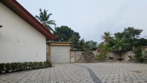 a house with a garage and a brick driveway at Prince Cottage - Entire Private Cottage in Kesbewa