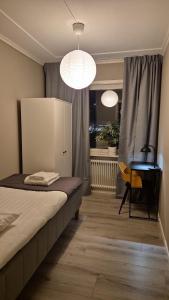 a bedroom with a bed and a desk and two lights at RåneVillan in Råneå