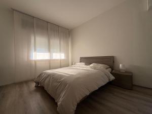 a white bedroom with a bed and a window at L'angolo di Alice -Fronte ospedale- in Udine