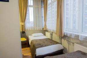 a small room with two beds and windows at Tac Hotel in Ankara