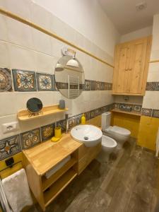 a bathroom with a sink and a toilet and a mirror at INDUSTRIAL CHIC HOUSE - Private parking in Orvieto +24 photos