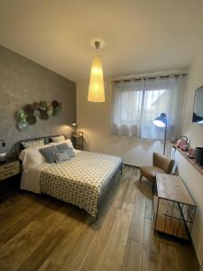 a bedroom with a bed and a chair and a window at INDUSTRIAL CHIC HOUSE - Private parking in Orvieto