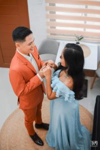 a man standing next to a woman in a blue dress at Woodlands Condotel in Bulan