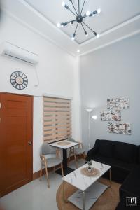a living room with a black couch and a table at Woodlands Condotel in Bulan