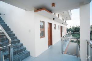 a staircase leading up to a white building with a door at Woodlands Condotel in Bulan