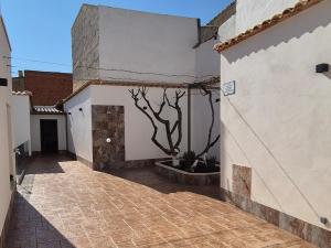 a courtyard of a building with a tree on the side at En Ca La Abuela Casa Rural in Consuegra