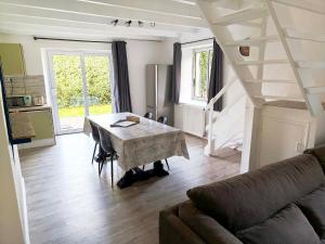 a living room with a table and a couch at Gite Les Sables Blancs in Plobannalec-Lesconil