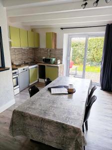 a kitchen with a table with chairs and a table and a tableablish at Gite Les Sables Blancs in Plobannalec-Lesconil
