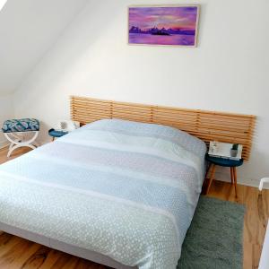 a bedroom with a large bed with a wooden headboard at Gite Les Sables Blancs in Plobannalec-Lesconil