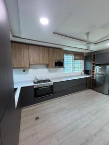 a large kitchen with wooden cabinets and a stove at Ankyease Aclove in Kotrope