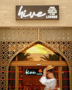 a woman walking in front of a store at Sheraton Oman Hotel, Muscat in Muscat