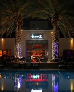 a pool in front of a bar with palm trees at Sheraton Oman Hotel, Muscat in Muscat +179 photos
