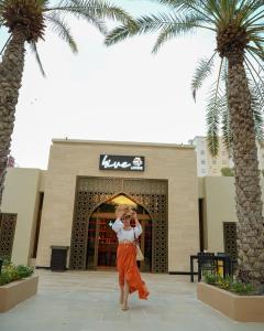 a woman taking a picture in front of a building at Sheraton Oman Hotel, Muscat in Muscat